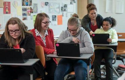 Student teacher in classroom helping students